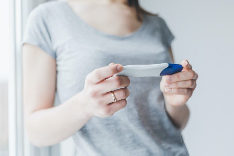 Woman looking and checking home free pregnancy test